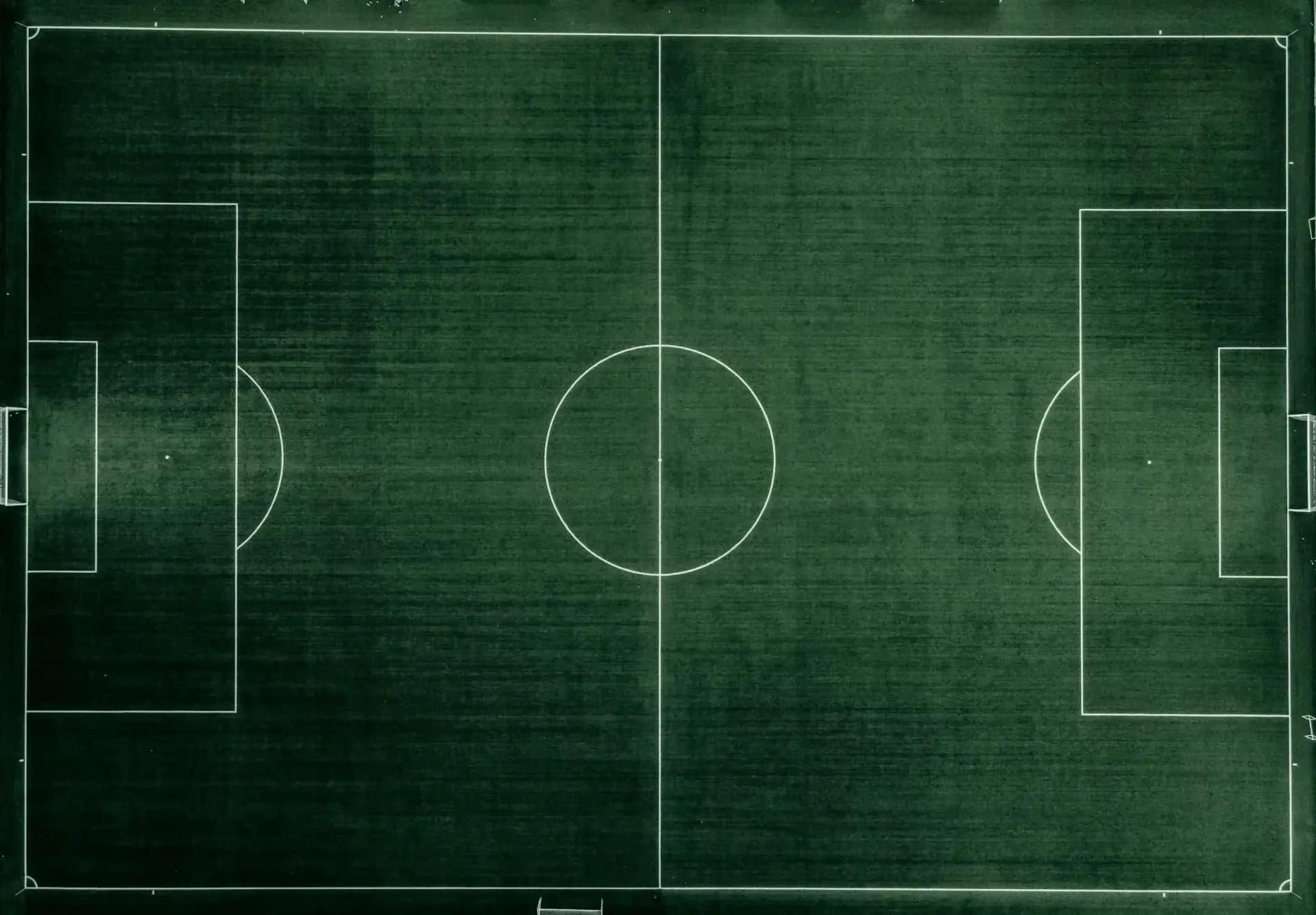 Luftaufnahme eines leeren Fussballplatzes: Mittelkreis, Strafräume und Seitenlinien von oben
