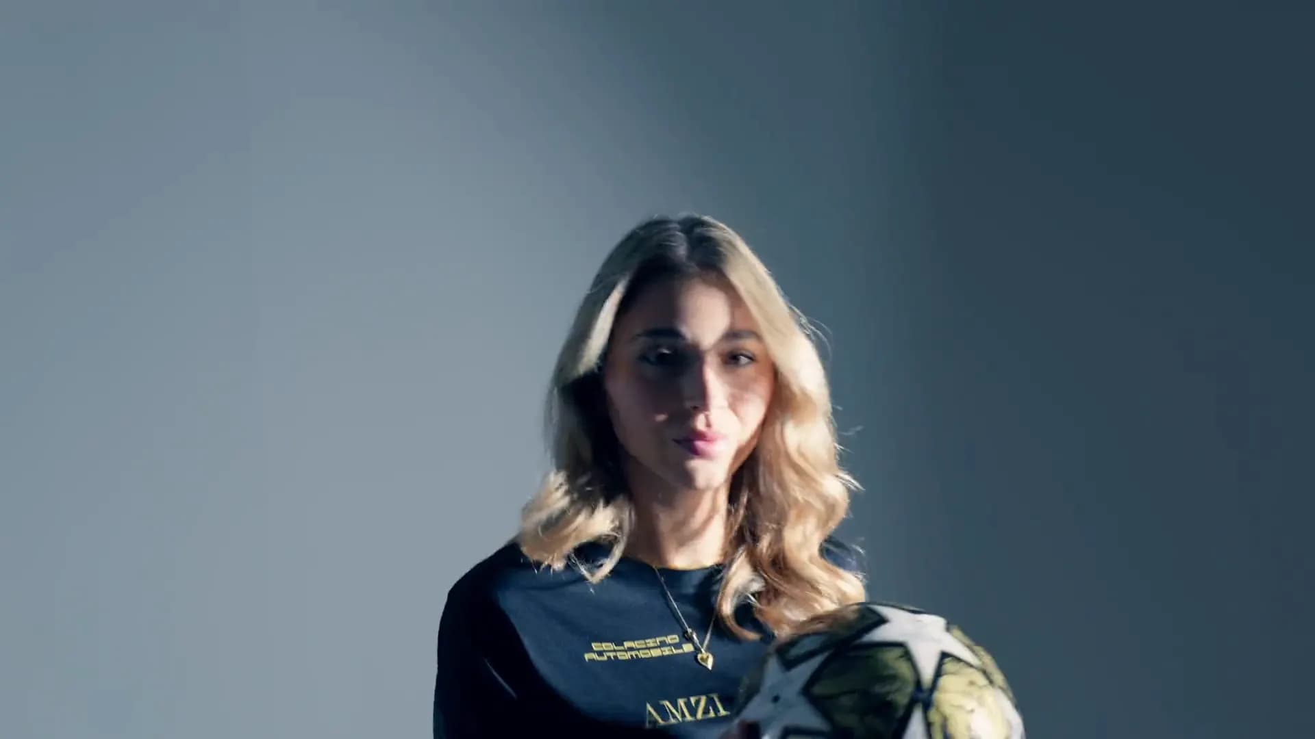 Spielerin im schwarzen Trikot von Amzi Legacy hält einen Ball vor sich, Studioaufnahme