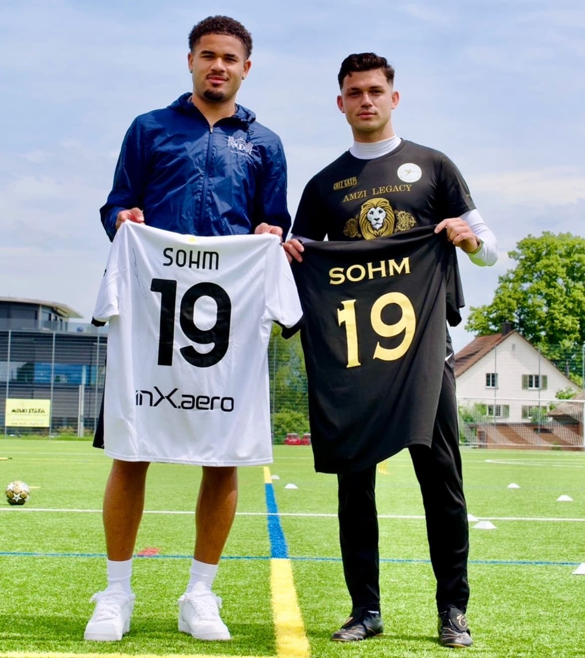 Simon Sohm und Miralem Amzi halten zwei Trikots mit der Nummer 19 in die Kamera, eines weiss, eines schwarz
